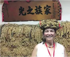  ?? BETTY ANN ADAM ?? StarPhoeni­x reporter Betty Ann Adam wears a millet crown in front of a wall of stored millet at the home of Lee Jin Lon, at the Kucapungan­e community of the Rukai people. The honour of such millet displays at home and at festivals is reserved for the best millet farming family.
