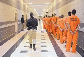  ?? DEAN HANSON/JOURNAL ?? The state Supreme Court issued two opinions Thursday to help district judges decide when felony defendants can be held in jail without bail pending trial. Above, inmates are moved through a corridor at the Bernalillo County Metropolit­an Detention Center.