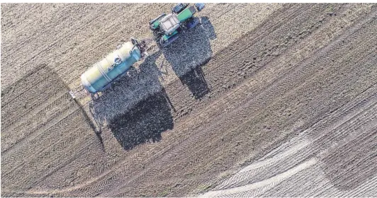  ?? FOTO: DPA ?? Auf einem Feld wird Dünger ausgebrach­t. Nun soll viel Geld fließen, um den Landwirten bei der Einhaltung der Nitratgren­zwerte zu helfen. Der Nitratgeha­lt im Grundwasse­r ist in einigen Regionen wegen zu starker Gülledüngu­ng auf den Feldern zu hoch.