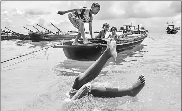  ??  ?? Moken children playing in shallow waters in front of their home in Nyaung Wee village.