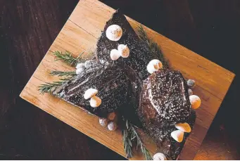  ?? Photos by AAron Ontiveroz, The Denver Post ?? To finish, cover everything with ganache using a spatula or spreader. Don’t worry about getting a perfect covering; it looks even better if you make bark-like marks with your spreader.