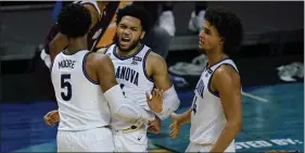  ?? MICHAEL CONROY - THE ASSOCIATED PRESS ?? NCAA Tournament rookies, from left, Justin Moore, Caleb Daniels and Jeremiah Robinson-Earl celebrate a defensive stop in the second half of Friday’s 73-63victory over Winthrop in the first round.