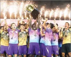  ?? SRENG MENG SRUN ?? NagaWorld striker George Bisan holds aloft the trophy on Saturday after his side won the 2018 Metfone C-League title.