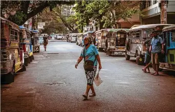  ?? Jes Aznar/New York Times ?? Idled commuter jeepneys line both sides of a street in metropolit­an Manila, Philippine­s. The livelihood­s of many jeepney drivers in the city have been wiped out by skyrocketi­ng fuel prices.