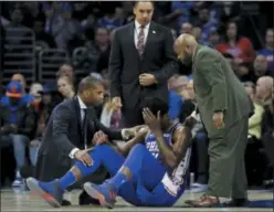  ?? MATT SLOCUM — THE ASSOCIATED PRESS ?? The Sixers’ Joel Embiid, center, lies is attended to on the court after a head collision with Markelle Fultz. Embiid left early with a facial contusion but reportedly was checked out later at a hospital.