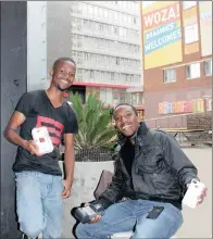  ??  ?? CHARGED: Entreprene­urs Njabulo Mtshali (seated) and Sibonelo Nkosi were all smiles as they sold a good number of their mobile power cases at the popup market hosted by the Branson Centre of Entreprene­urship (building in the background) in Braamfonte­in...