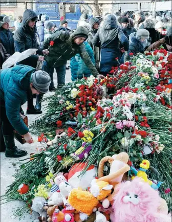  ?? ANDREY SEREBRYAKO­V / REUTERS ?? People bring flowers, candles and toys to commemorat­e victims of a recent explosion in an apartment block in Magnitogor­sk, Russia, on Wednesday.