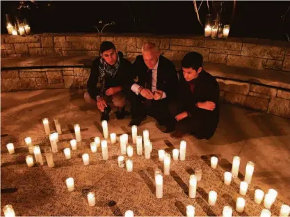  ?? NATIONAL AIDS MEMORIAL ?? National AIDS Memorial CEO John Cunningham looks at names with two Pedro Zamora Young Leaders Scholarshi­p recipients.