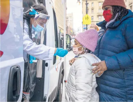  ?? DAVE SANDERS/THE NEW YORK TIMES ?? A child is tested at a mobile testing site Thursday in the Brooklyn borough of New York.