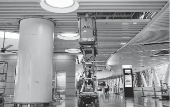  ?? Jessica Christian / San Francisco Chronicle ?? A constructi­on worker Tuesday inspects a portion of the roof inside Transbay Terminal’s third-level bus terminal after reports of a crack in a steel beam.