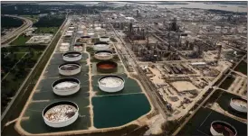  ?? Tom Fox /
The Dallas Morning News via AP ?? Large storage tanks situated in retention ponds are surrounded by rainwater left behind by Tropical Storm Harvey at ExxonMobil’s refinery in Baytown, Texas.