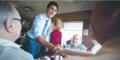  ??  ?? Le premier ministre Justin Trudeau discute avec des clients lors d’un petit-déjeuner au Silks Country Kitchen à Niagara-on-the-Lake, en Ontario. - La Presse canadienne: Peter Power