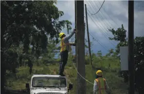  ?? Ramon Espinosa / Associated Press ?? Workers remove old electric cables in San German. An eight-month, $3.8 billion federal effort is trying to end the longest blackout in U.S. history.