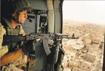  ?? Associated Press 2017 ?? A Russian soldier patrols in September in a military helicopter flying over Palmyra, Syria. Russian forces recently deployed near the Syria-Lebanon border but withdrew a day later.