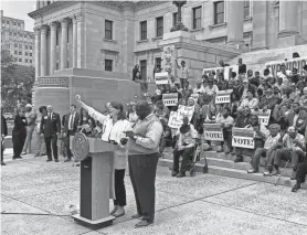  ?? GRANT MCLAUGHLIN/MISSISSIPP­I CLARION LEDGER ?? Left to right, Brittany Caldwell and Rev. Greggory Divinity, as well as more than 120 others shout “full expansion now,” Tuesday on the Southern steps of the Mississipp­i State Capitol Building. Caldwell and Divinity were two of several religious leaders to urge lawmakers to fully expand Medicaid in Mississipp­i for more than 160,000 people and declare April 16 as Medicaid Expansion Day.