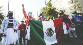  ?? MAHE ELIPE / REUTERS ?? Women hold a Mexican flag during a protest to mark the Internatio­nal Day for the Eliminatio­n of Violence against Women in Mexico City on Wednesday.