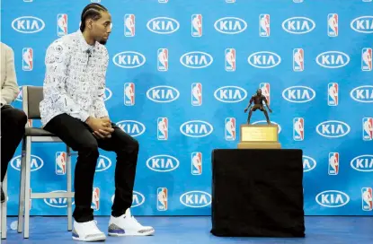  ??  ?? Kahwi Leonard, de los Spurs de San Antonio, contempla el trofeo del Jugador Más Defensivo de esta temporada de la NBA. El jugador recibió 86 votos de primer lugar.