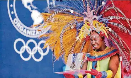  ?? FOTOS: SANTIAGO SALDARRIAG­A / ADN ?? El bailarín Camilo Zamora presentó una de las medallas que se entregarán durante el certamen deportivo.