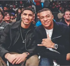  ?? FOTOS: AFP ?? AMIGOS. En primera fila, Mbappé y Hakimi vieron un partido de básquet y un video especial que le prepararon al astro francés. Y luego ambos en Times Square, de incógnito.