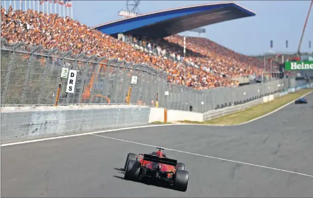  ??  ?? Leclerc pilota su Ferrari ayer en Zandvoort delante de una grada abarrotada de aficionado­s ‘naranjas’.