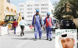  ?? — AFP ?? DOHA: Migrant workers are seen walking next to a constructi­on site in the Qatari capital on Dec 6, 2016. (Inset) Qatari Labor Minister Issa bin Saad Al-Nuaimi holds a press conference on reforming Qatar’s labor laws and practices yesterday.