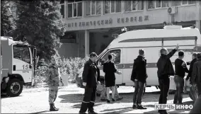  ?? KERCH INFO NEWS VIA AP ?? POLICEMEN, MEDICS AND INVESTIGAT­ORS stand near the vocational college in Kerch, Crimea on Wednesday. An 18-yearold student strode into his vocational school in Crimea, a hoodie covering his blond hair, then pulled out a shotgun and opened fire on Wednesday, killing 19 students and wounding more than 50 others before killing himself.