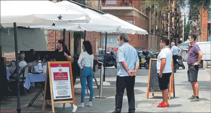  ?? FOTO: EFE ?? Varios clientes esperan mesa en una terraza del barrio barcelonés de la Barcelonet­a. La ciudad entró ayer en la fase 1 de la desescalad­a