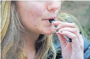  ?? [AP PHOTO] ?? In this April 11 photo, an unidentifi­ed 15-year-old high school student uses a vaping device near the school’s campus in Cambridge, Mass.