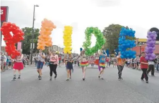  ?? Seth McConnell, Special to The Denver Post ?? Marchers hold up balloons spelling out “Pride” during the Coors Light PrideFest Parade along Colfax Avenue in Denver on Sunday.