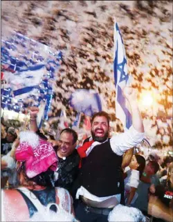  ??  ?? Israelis celebrate the swearing in of the new government in Tel Aviv, June 13. Israel’s parliament has voted in favor of a new coalition government, formally ending Prime Minister Benjamin Netanyahu’s historic 12-year rule. Naftali Bennett, a former ally of Netanyahu became the new prime minister. (AP)