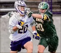  ?? James Franco / Special to the Times Union ?? UAlbany’s Thomas Decker takes a hit from Vermont’s Dobson Cooper during their game on Saturday.