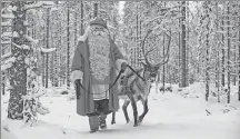  ?? PROVIDED TO CHINA DAILY ?? Santa Claus makes an appearance with one of his reindeers in Rovaniemi, Finland.