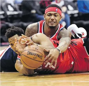  ?? NICK WASS / THE ASSOCIATED PRESS ?? Wizards guard Bradley Beal, top, battles for the ball with Raptors guard Kyle Lowry on Sunday in Washington. Toronto won in double overtime, 140-138.