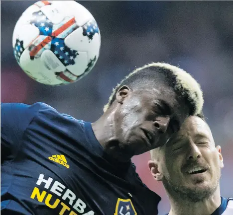  ?? THE CANADIAN PRESS ?? L.A. Galaxy’s Gyasi Zardes, left, and the Whitecaps Jordan Harvey collide as they vie for the ball in Vancouver Saturday.