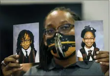  ?? ASSOCIATED PRESS FILE PHOTO ?? FILE - In this Tuesday, Oct. 27 file photo, Sheldon Smith, center, holds the photograph­s of his children Deshawn Smith, 11, left, and Trinitee Smith, 13, both suffering from sickle cell anemia, during an Initiative 65 rally in Ridgeland, Miss. Smith and his wife Keishawna Smith believe their children would benefit from medical marijuana treatment for pain management. Initiative 65 would amend the Mississipp­i Constituti­on to allow the prescripti­on by a doctor of up to 5 ounces (142 grams) of marijuana per month for people who suffer from more than 20 medical conditions. The state lawmakers are offering a more restrictiv­e measure as an alternativ­e.