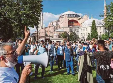  ?? AFP PIC ?? A man chanting progovernm­ent slogans with a megaphone as people gather in front of Hagia Sophia in Istanbul on Saturday.