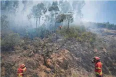  ?? — AFP ?? Spanish military firefighte­rs from the Emergency Military Unit (UME) prepare to tackle a wildfire in Cernache de Bomjardim in Serta on Tuesday.