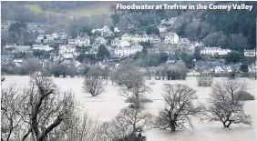  ??  ?? > Floodwater at Trefriw in the Conwy Valley