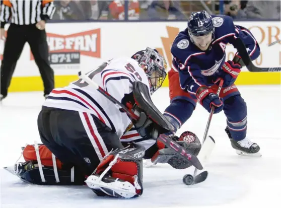  ?? GETTY IMAGES ?? Goalie Corey Crawford makes a save against the Blue Jackets’ Cam Atkinson in the second period. Crawford stopped 37 shots to get his first win since Dec. 17.