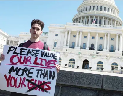  ?? AFP VIA GETTY IMAGES FILE ?? Amit Dadon, a graduate in 2017 from Florida’s Marjory Stoneman Douglas High School, a site of a mass shooting, poses on the West Lawn of the U.S. Capitol after rallying in April 2018 with fellow students calling for stricter gun laws.