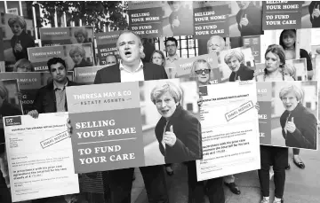  ??  ?? Liberal Democrat campaigner­s protest against Britain’s Prime Minister Theresa May’s social care policy outside the Conservati­ve Party headquarte­rs in London, Britain. — Reuters photo