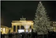  ?? MARKUS SCHREIBE — THE ASSOCIATED PRESS FILE ?? In this file photo, a giant Hanukkah menorah, center, set up by the Jewish Chabad Educationa­l Center, is illuminate­d at the Pariser Platz in front of the Brandenbur­g Gate in Berlin. Menorah lightings are planned there again this year for Hanukkah,...