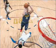  ?? ISAIAH J. DOWNING / REUTERS ?? Nivel. Nikola Jokic (c) burla la marca de un adversario para poder encestar.