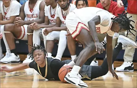  ?? Photos by Justin Guido/For the Post Gazette ?? Gateway’s Dwight Ricketts, left, fights for a loose ball with Penn Hills’ Darien Roberson during the Jack Twyman Tip-Off Classic on Friday at Central Catholic Alumni Hall.