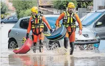  ?? FRED LANCELOT THE ASSOCIATED PRESS ?? Rescue workers wade through muddy waters searching for survivors in the town of Trebes, southern France, Monday. Flash floods tore through towns in southwest France..