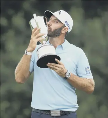  ??  ?? 0 Dustin Johnson kisses the trophy after his one-shot victory in the Travelers Championsh­ip.