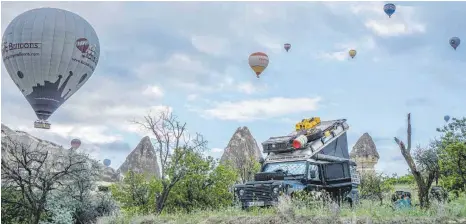  ??  ?? Dreh- und Angelpunkt während der Weltreise ist der Land Rover Defender Calimero. So wie hier vor Heißluftba­llons in Kappadokie­n, Türkei.