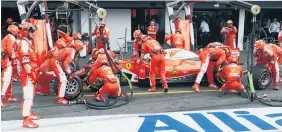  ??  ?? Kimi Raikkonen is swarmed by Ferrari pit crew.