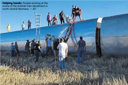  ?? — ap ?? Helping hands: people working at the scene of the amtrak train derailment in north-central Montana.