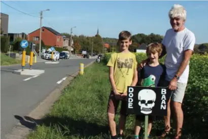  ?? FOTO FRPE ?? Gido Vanlessen met zijn kleinkinde­ren bij een van zijn borden. “Zelfs met wegscheide­rs is het hier nog gevaarlijk.”